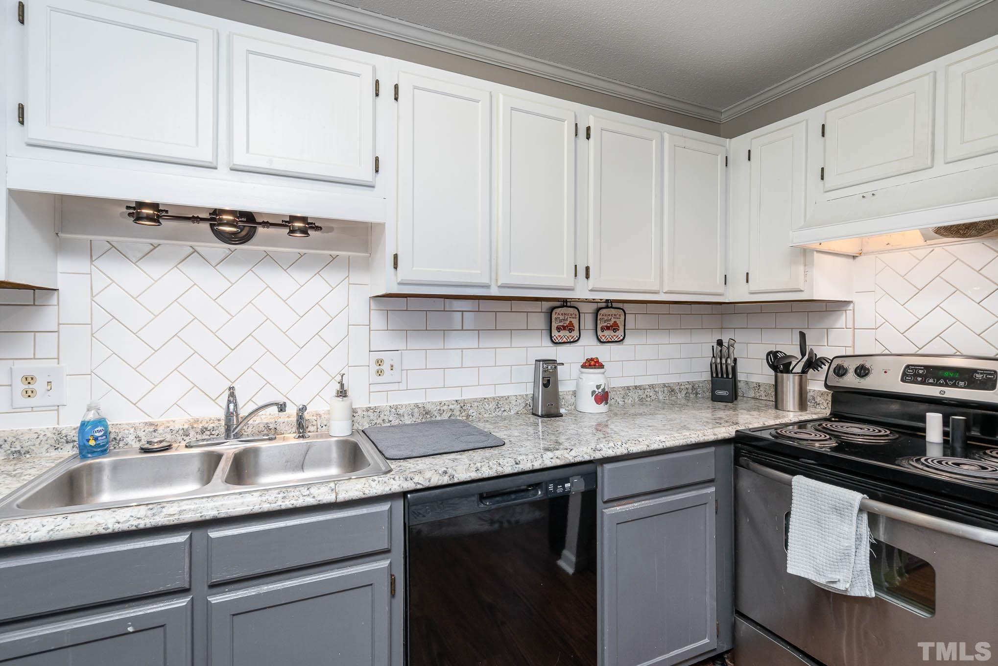 4701 Courtside Place Raleigh, NC 27604 - Photo 9 of 30 a kitchen with stainless steel appliances granite countertop a sink stove and cabinets