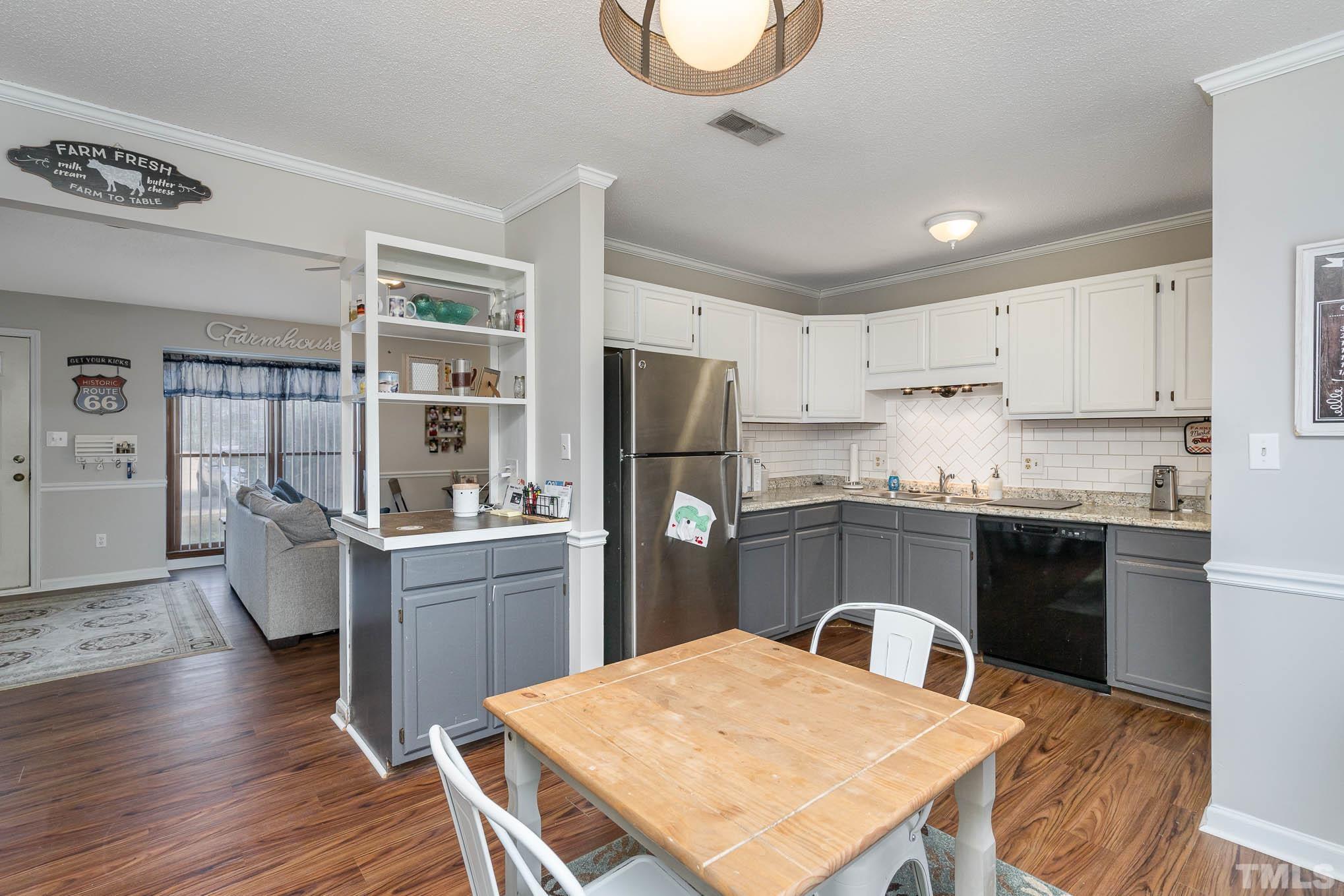 4701 Courtside Place Raleigh, NC 27604 - Photo 10 of 30 a kitchen with refrigerator cabinets dining table and chairs