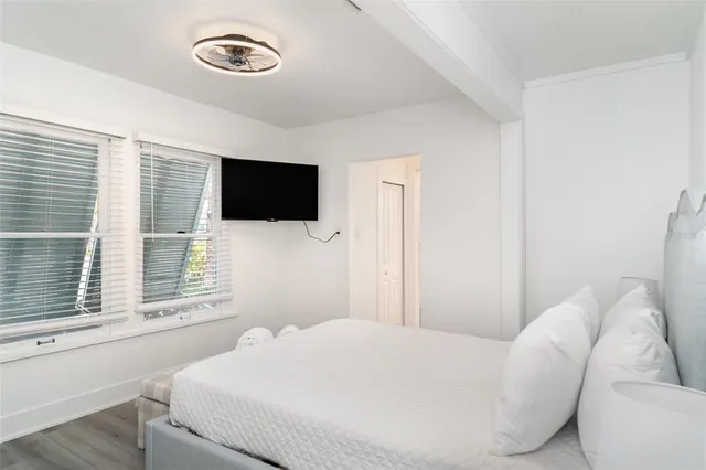 a bedroom with a bed and a flat tv screen on the dresser