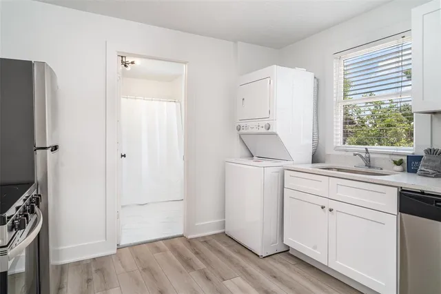 a kitchen with stainless steel appliances a refrigerator a stove and white cabinets