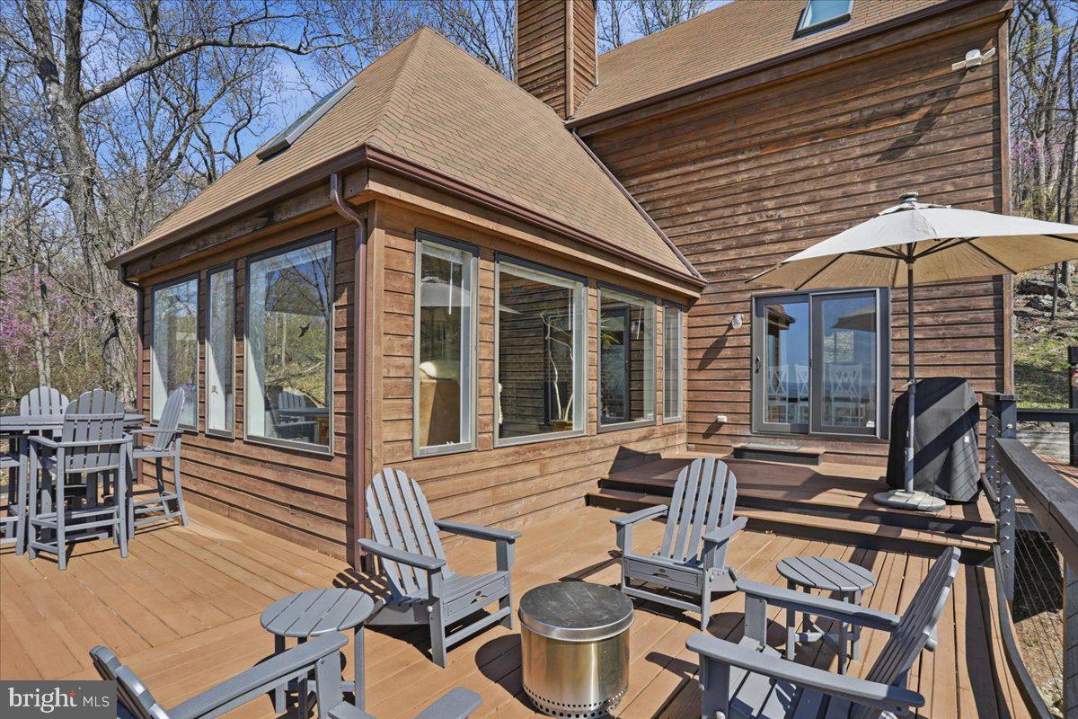 19897 Foresthill Road Bluemont, VA 20135 - Photo 6 of 39 a view of a patio with table and chairs under an umbrella with wooden floor and fence