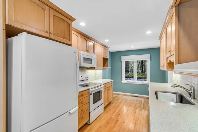 a kitchen with stainless steel appliances granite countertop a stove a sink and a refrigerator