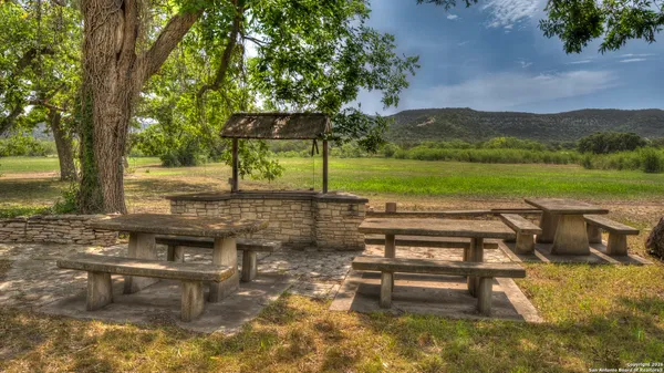 a view of a lake with a bench and trees