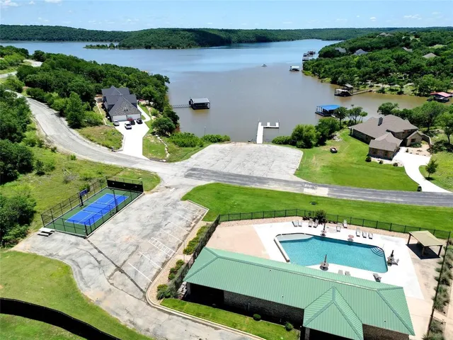 an aerial view of a house with a yard and lake view