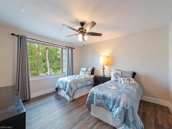 a bedroom with two beds and a large window