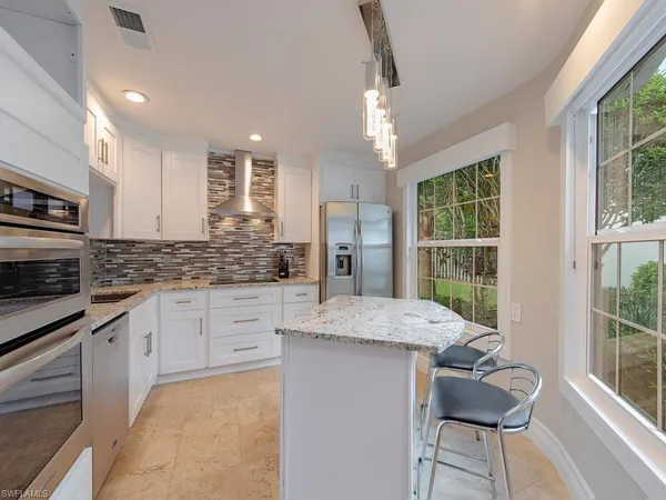a kitchen with granite countertop cabinets and chair