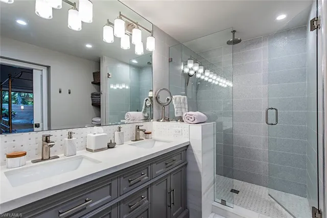 a bathroom with a sink a large mirror and shower