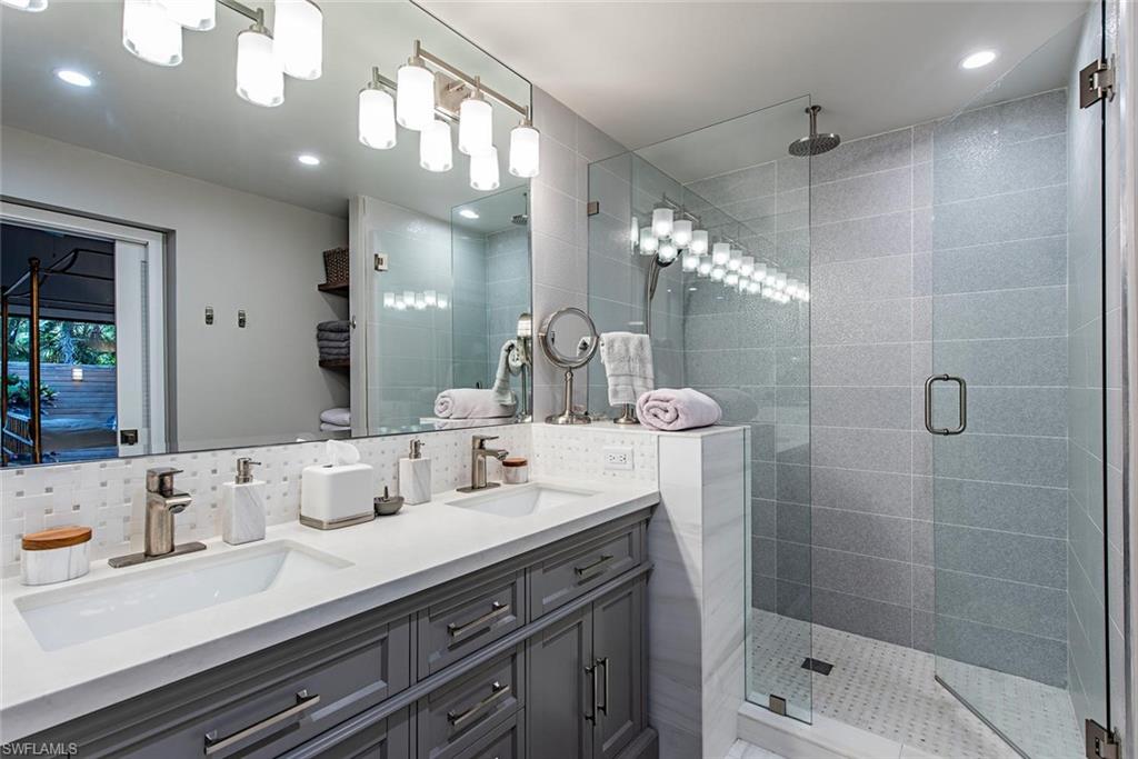 840 Meadowland Drive, Unit H Naples, FL 34108 - Photo 8 of 14 a bathroom with a sink a large mirror and shower