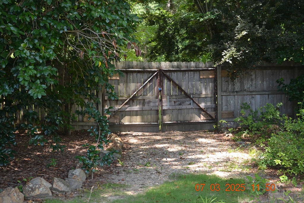13642 Macon Road Upatoi, GA 31829 - Photo 23 of 34 a view of wooden house with a small yard and wooden fence