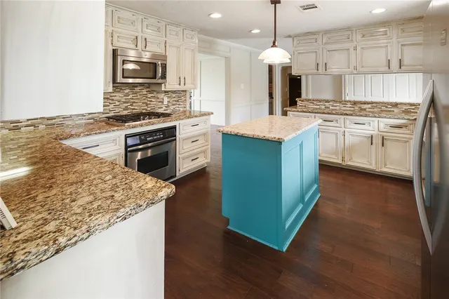 a kitchen with kitchen island granite countertop wooden cabinets and a sink