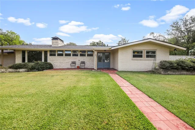 a view of a house with a yard and potted plants