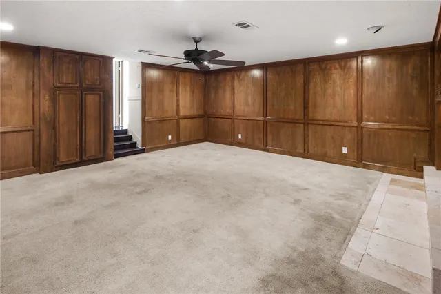 a view of an empty room with cabinet and a window