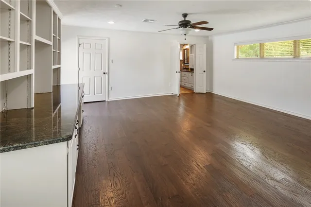a view of a swimming pool with a bench and trees in the background