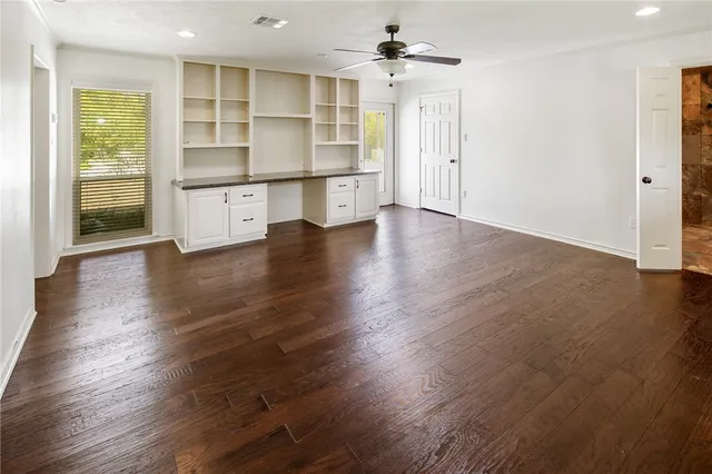 a spacious bathroom with a granite countertop sink a toilet a mirror and shower