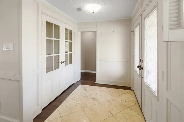 an empty room with wooden floor fireplace and windows