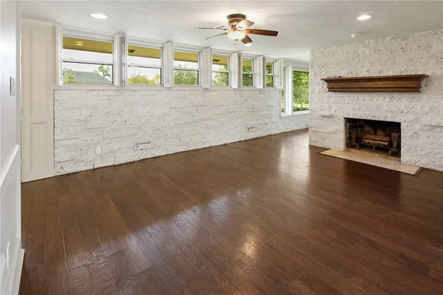 an empty room with windows and fireplace