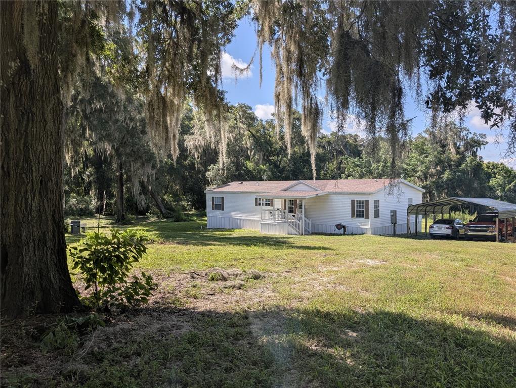 123 Amos Road Crescent City, FL 32112 - Photo 1 of 36 a front view of a house with a garden and trees
