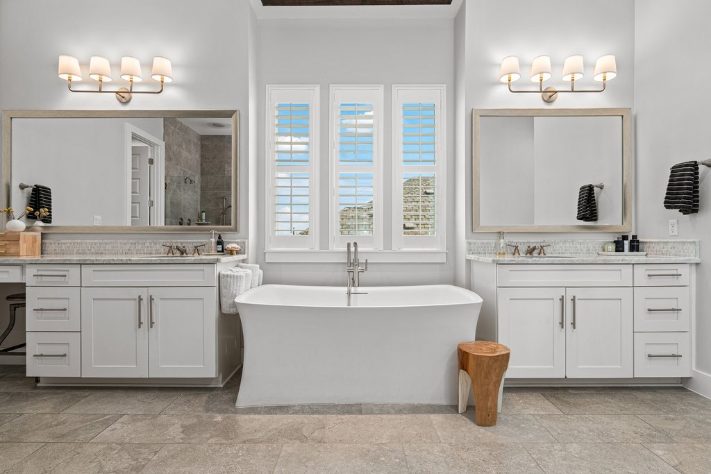 203 Lodestone Lane Austin, TX 78738 - Photo 26 of 40 Spacious bathroom featuring a freestanding soaking tub, dual vanity with white cabinetry, light-toned countertops, and large format floor tiling