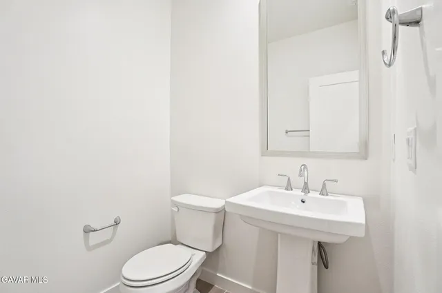 a white toilet sitting next to a bathroom sink