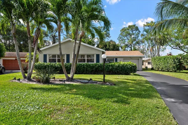 a view of a house with a backyard and a tree