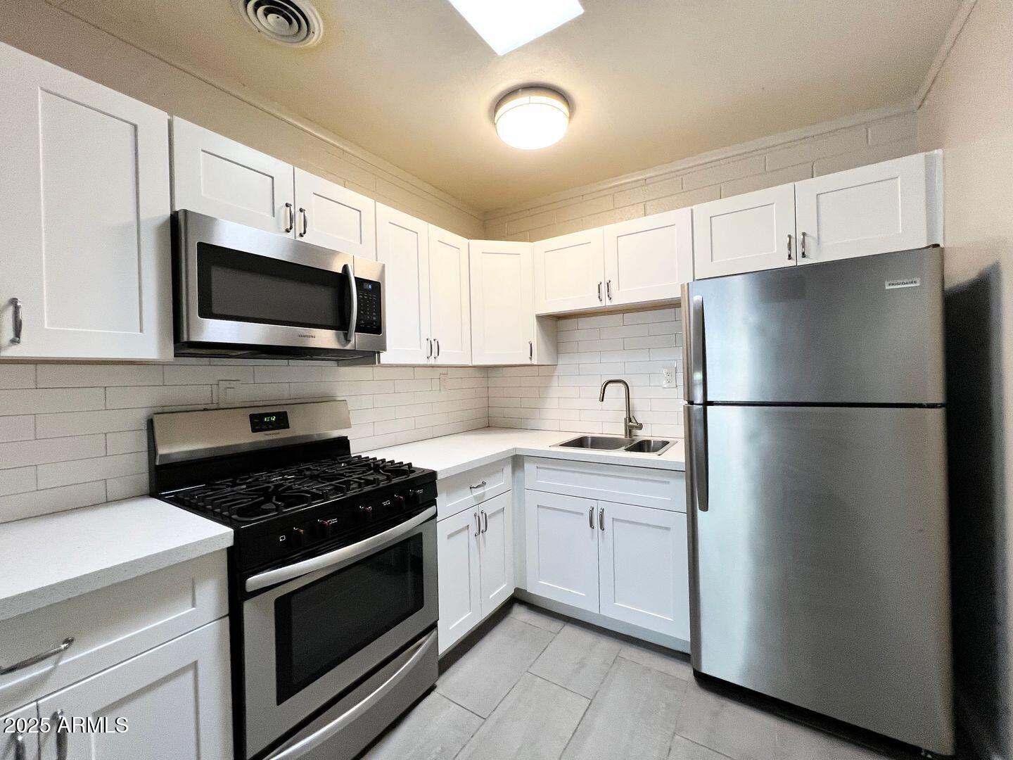 626 South Wilson Street Tempe, AZ 85281 - Photo 5 of 23 a kitchen with stainless steel appliances granite countertop a refrigerator stove a sink and a microwave