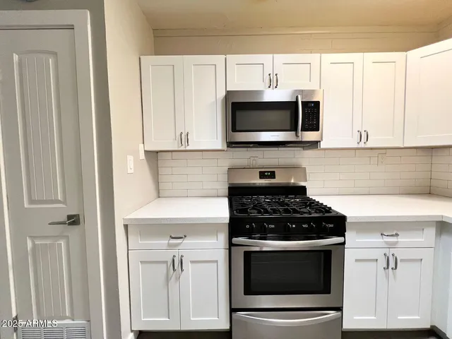 a kitchen with stainless steel appliances white cabinets and stove