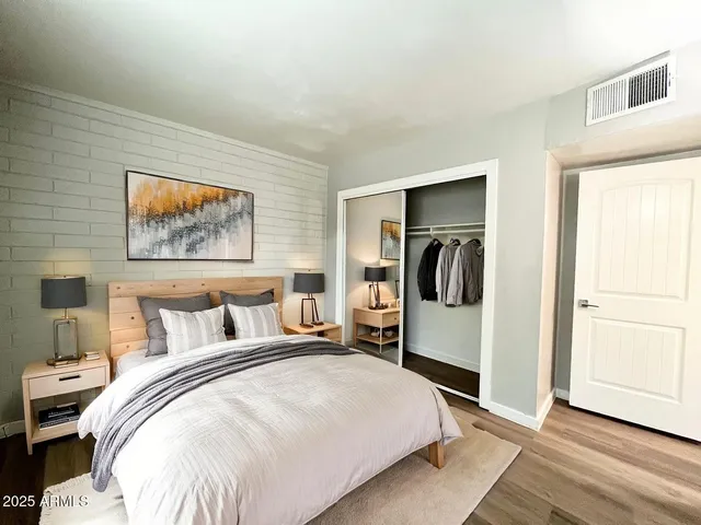 a bedroom with bed and wooden floor