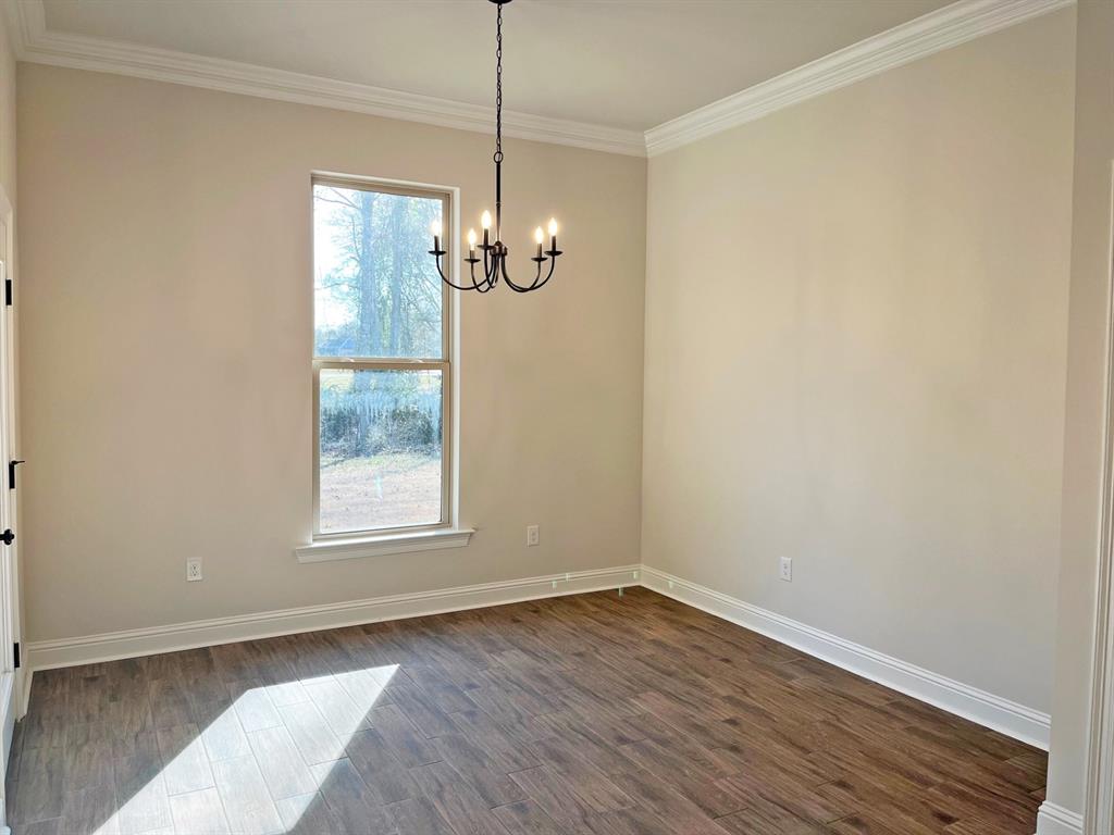187 Lessie Drive Stonewall, LA 71078 - Photo 12 of 29 an empty room with wooden floor chandelier and window