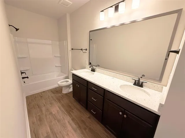 a bathroom with a double vanity sink a toilet and a mirror