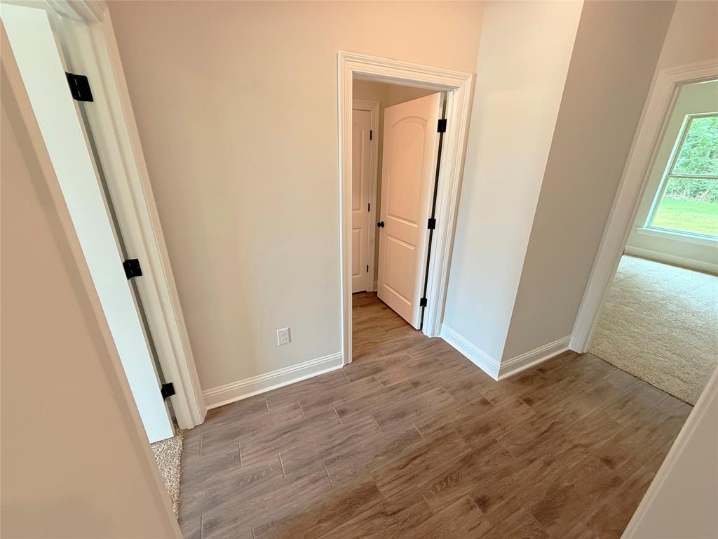 187 Lessie Drive Stonewall, LA 71078 - Photo 20 of 29 an empty room with wooden floor and a hallway