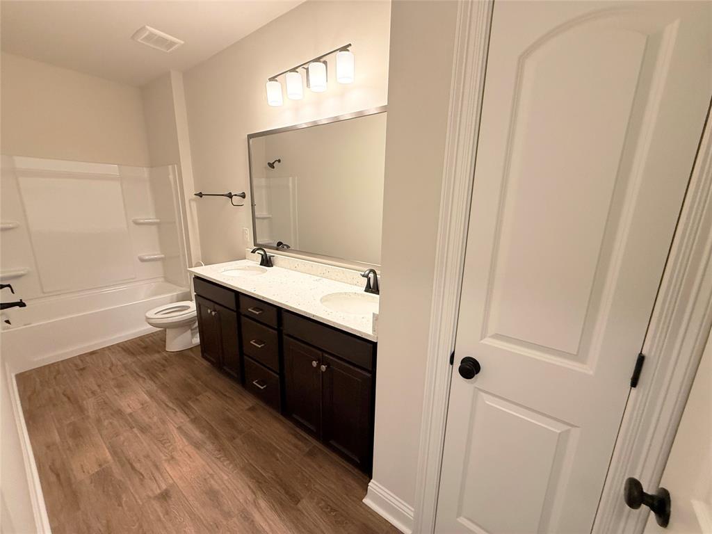 187 Lessie Drive Stonewall, LA 71078 - Photo 22 of 29 a spacious bathroom with a double vanity sink a mirror and a bathtub