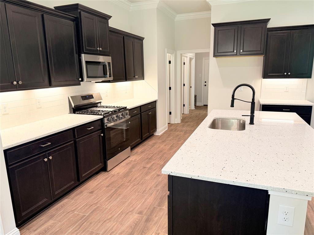 187 Lessie Drive Stonewall, LA 71078 - Photo 9 of 29 a kitchen with stainless steel appliances a sink dishwasher a stove top oven a refrigerator with wooden cabinets and wooden floor