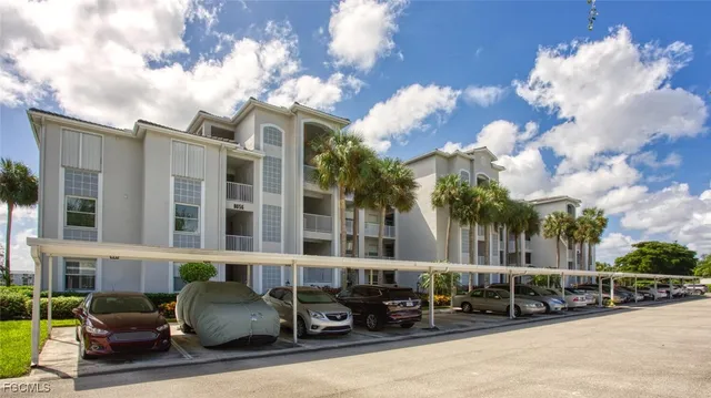 a front view of a building with parked cars