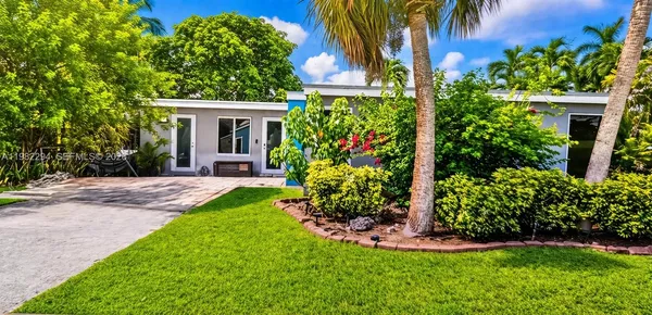 a view of a house with a yard and potted plants