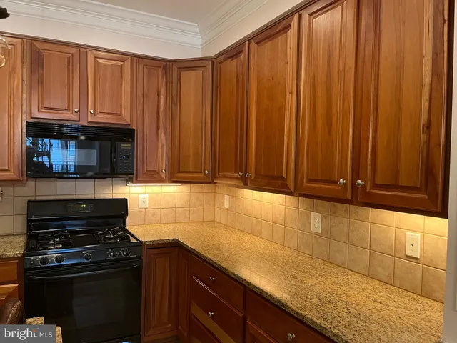 a kitchen with stainless steel appliances granite countertop a refrigerator a sink and wooden cabinets