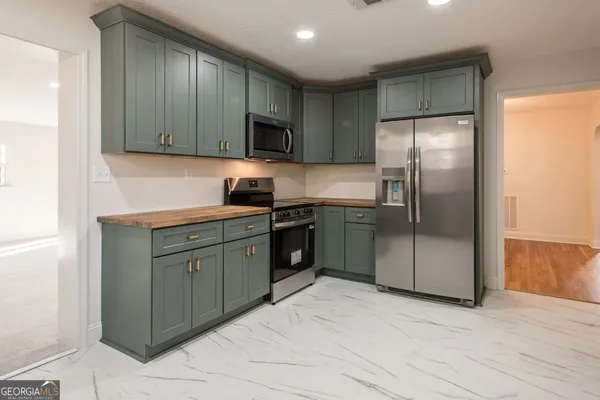 a kitchen with stainless steel appliances granite countertop a refrigerator and a sink