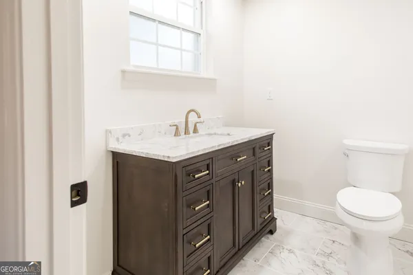 a bathroom with a sink a toilet and a mirror