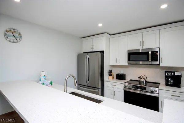 a kitchen with stainless steel appliances granite countertop a refrigerator sink and stove