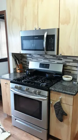 a stove top oven sitting inside of a kitchen