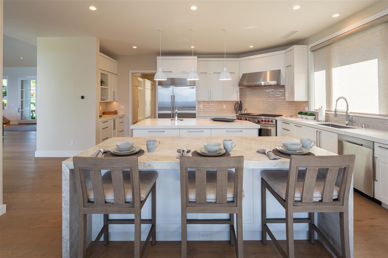 40 Hale Pili Way, Unit 15 Haiku, HI 96708 - Photo 12 of 27 a kitchen with kitchen island cabinets dining table and chairs