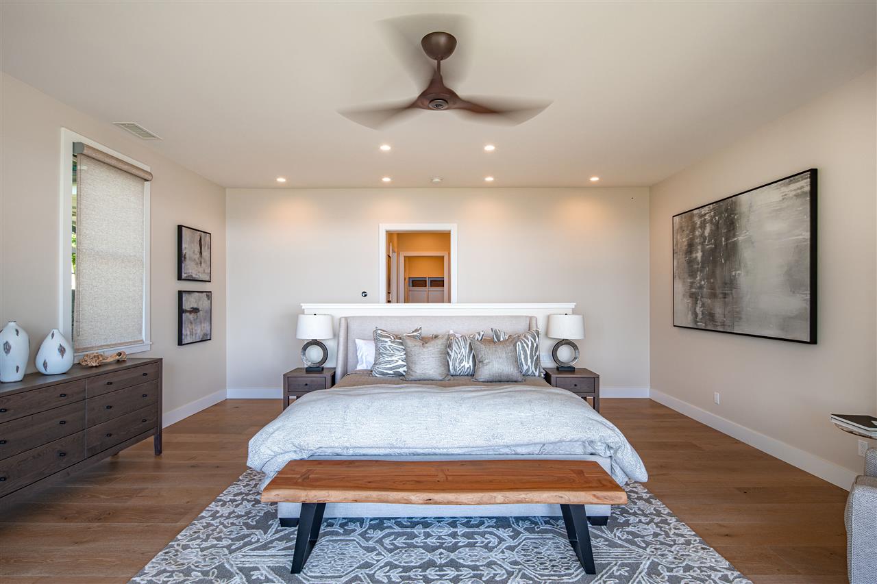 40 Hale Pili Way, Unit 15 Haiku, HI 96708 - Photo 15 of 27 a bedroom with a large bed and a chandelier