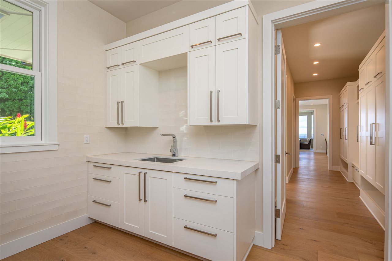 40 Hale Pili Way, Unit 15 Haiku, HI 96708 - Photo 26 of 27 a kitchen with white cabinets and wooden floor