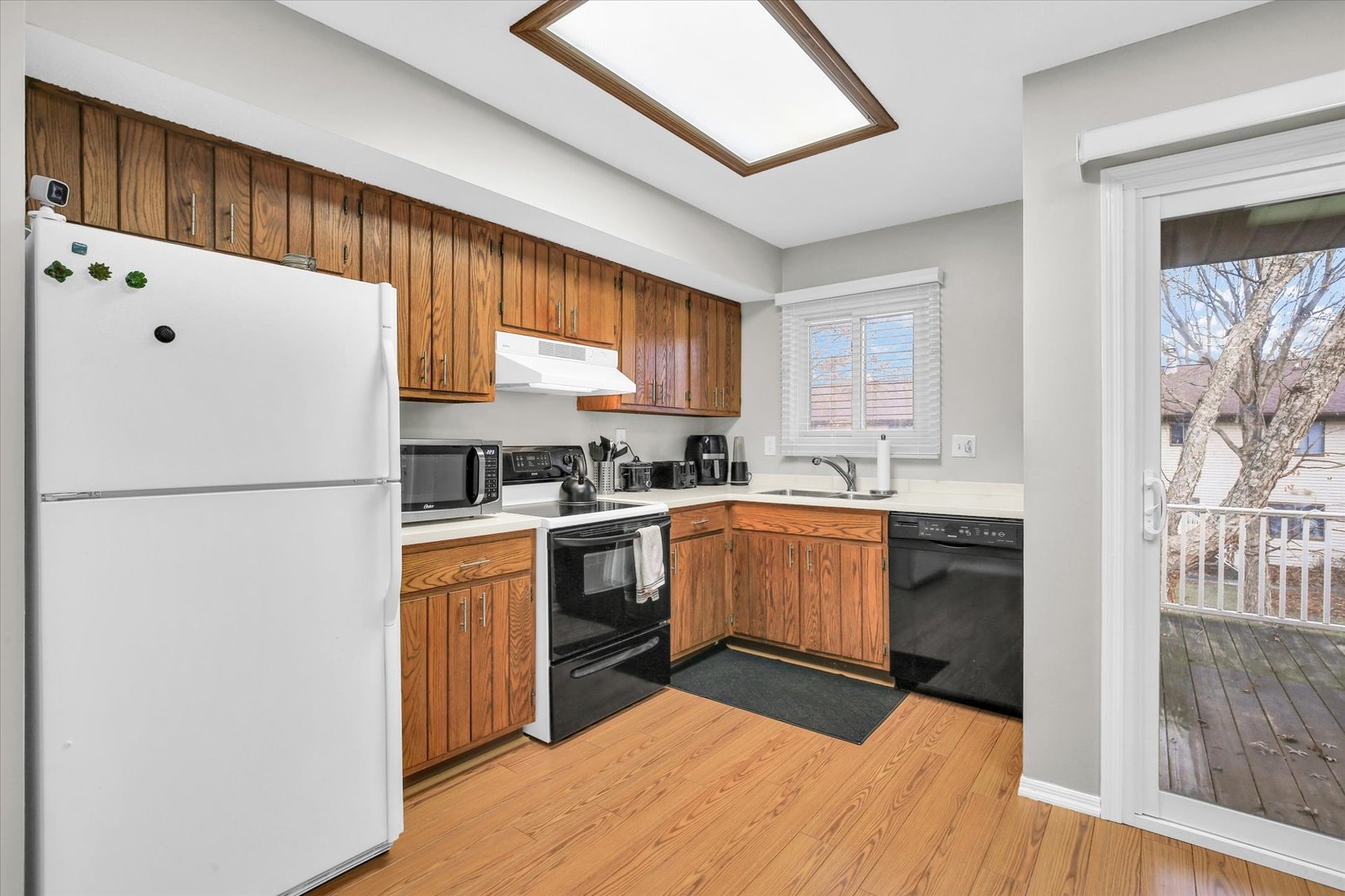 1802 Beck Drive, Unit 7 Urbana, IL 61802 - Photo 11 of 26 a kitchen with a refrigerator a stove top oven a sink and dishwasher with wooden floor