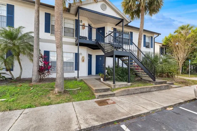 a front view of a house with a yard and potted plants