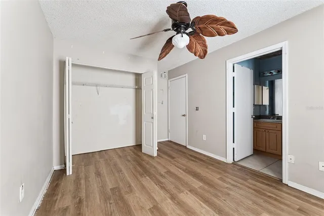 a view of a room with wooden floor closet and windows