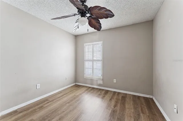 a view of a room with a hardwood floor and a ceiling fan