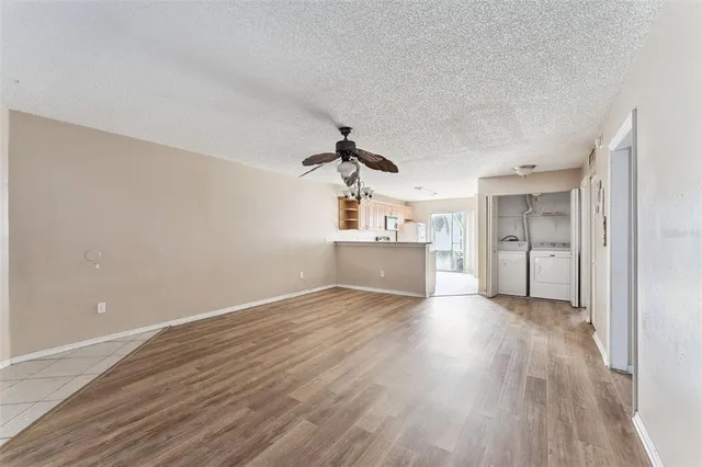 a view of empty room with wooden floor and windows