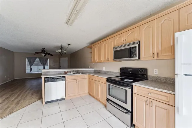 a kitchen with cabinets stainless steel appliances and a counter space
