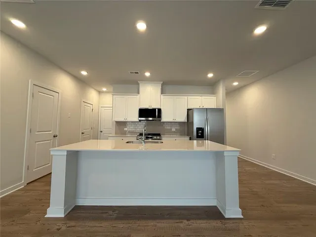 a large kitchen with kitchen island a island in it