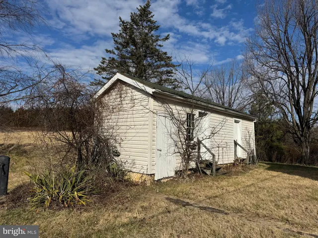 a view of an empty room with wooden floor and windows
